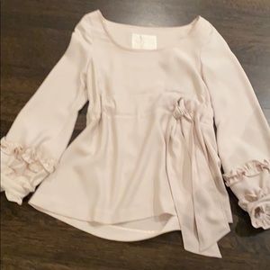 Elegant cream ruffle sleeve top with tie detail.